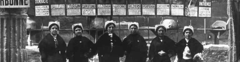 Groupe de femmes devant , les 12 pancartes symbolisant les degrés de patience du thermomètre des « meurt de faim » du Midi.
